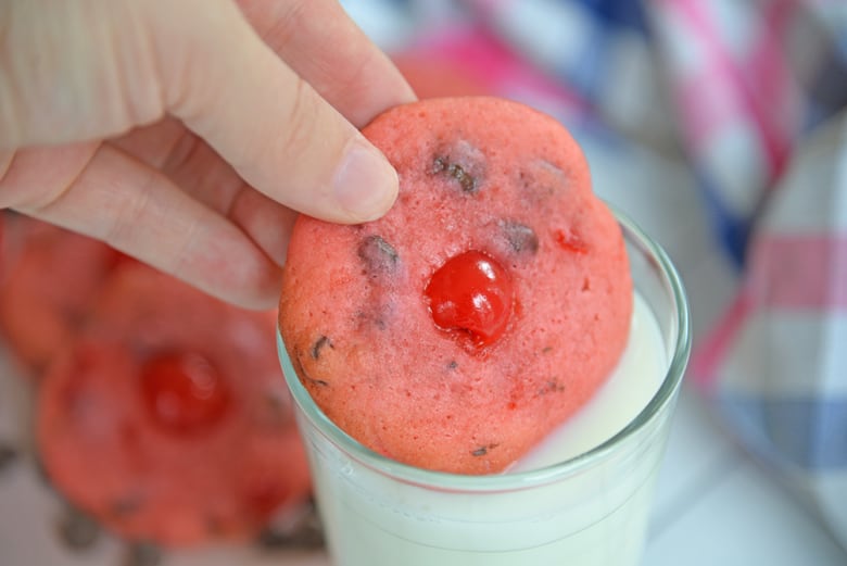 Cherry Chocolate Chip Cookie dipping into milk 