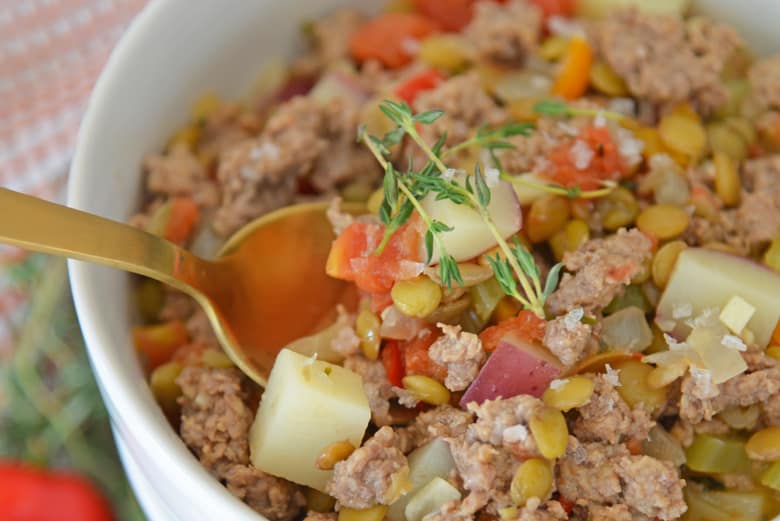 Gold spoon digging into lamb stew