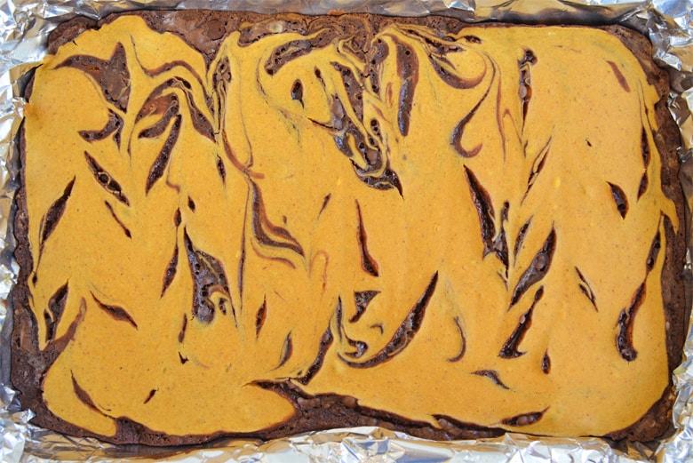 Overhead of a tray of Pumpkin Cheesecake Brownies swirled together