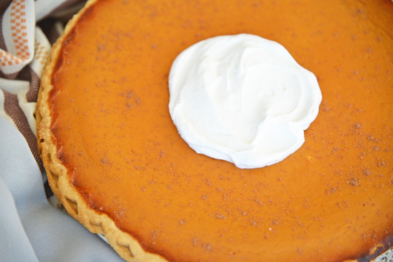 Smooth, uncracked pumpkin pie with whipped cream dollop 