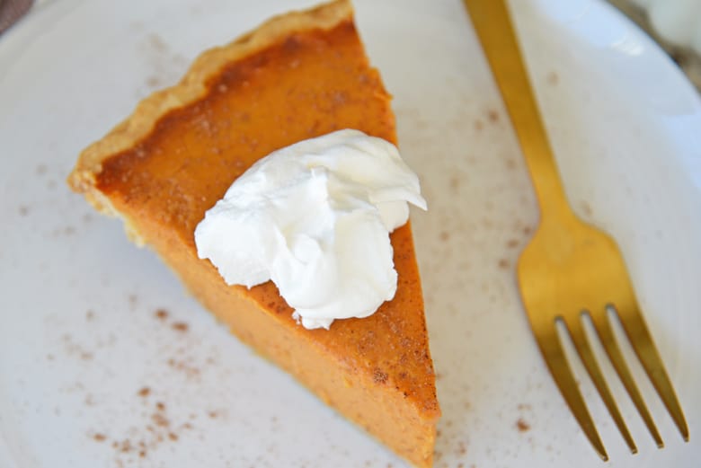 Slice of pumpkin pie with whipped cream