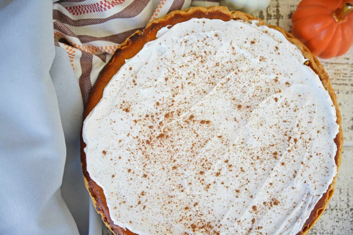 Whole frosted pumpkin pie with spice topping