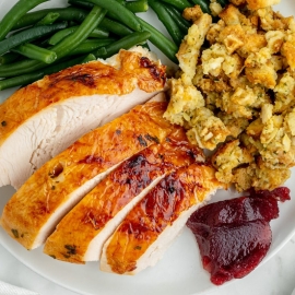 overhead plate of turkey with stuffing, cranberry sauce and green beans