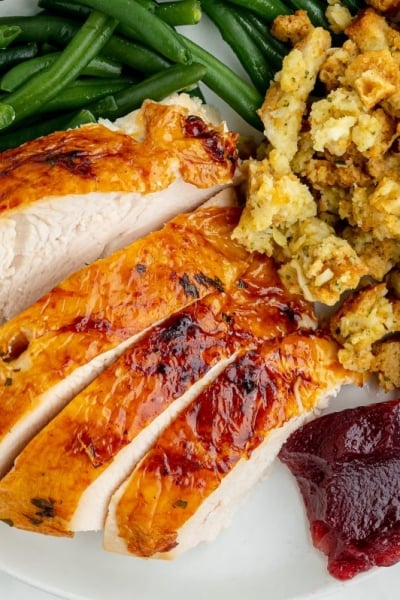 overhead plate of turkey with stuffing, cranberry sauce and green beans