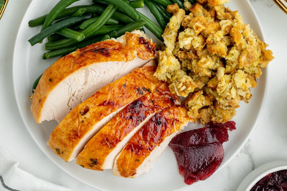overhead plate of turkey with stuffing, cranberry sauce and green beans