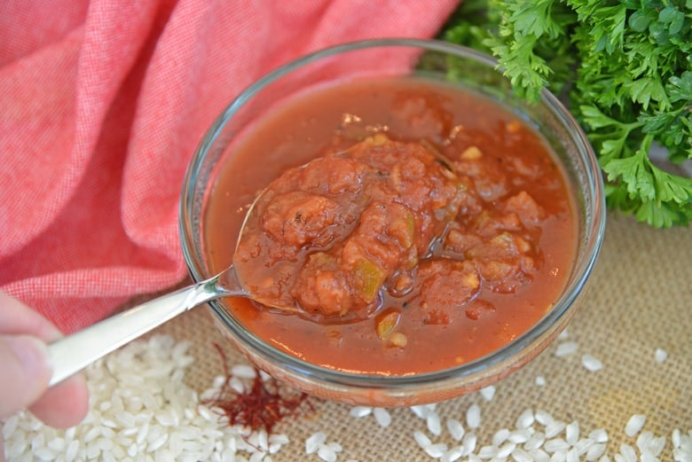 Salsa in a glass bowl with a spoon