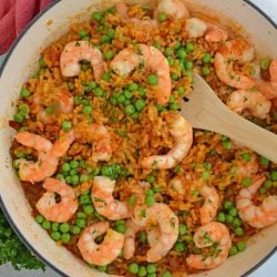 A bowl of food on a plate, with Paella