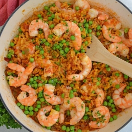 A bowl of food on a plate, with Paella