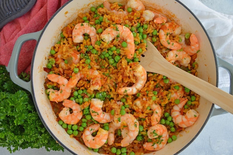 A bowl of food on a plate, with Paella