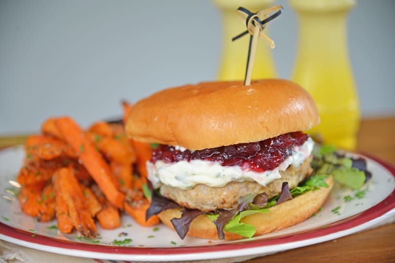 Thanksgiving turkey burger secured with a toothpick and garnished with sweet potato fries