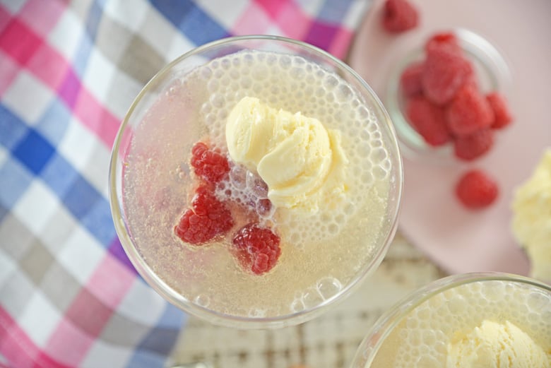 Overhead of champagne float with fresh raspberries 