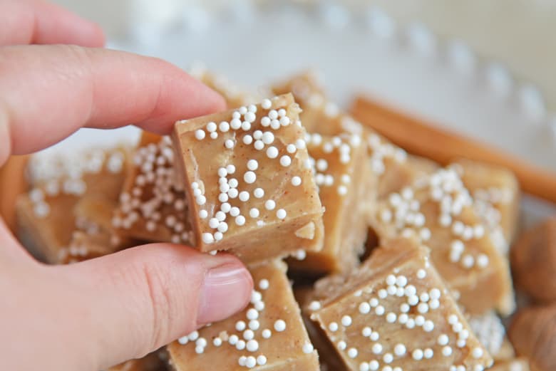 Hand picking up a square of gingerbread fudge 