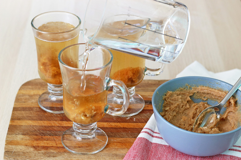 Water pouring into hot buttered rum cups 