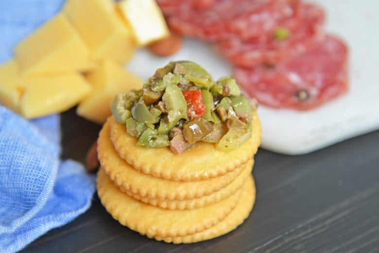 Olive tapenade on a stack of butter crackers 