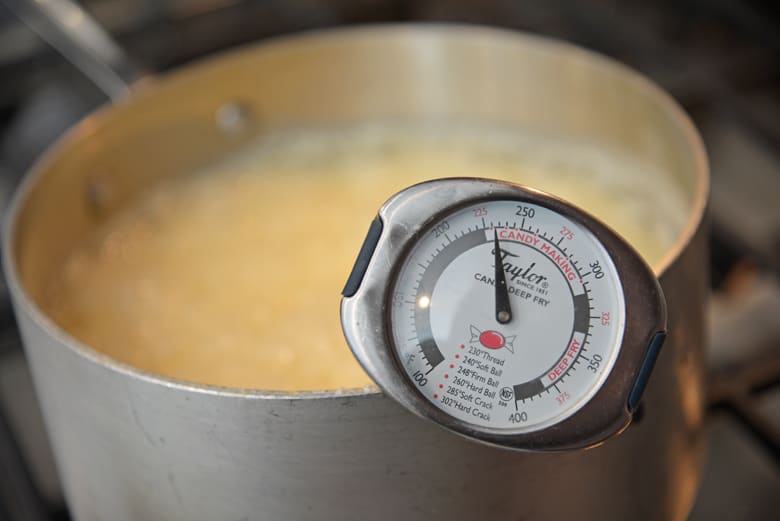 Candy thermometer in a saucepan of white fudge