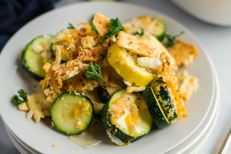 Close up of cheesy squash casserole with green and yellow squash  