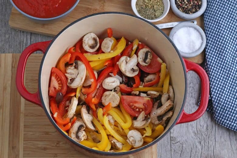 Vegetables for cacciatore in a red Dutch oven 