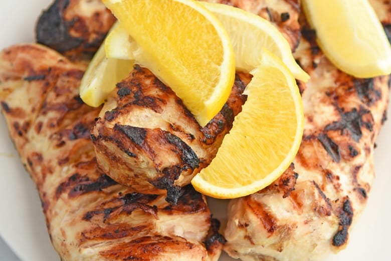 close up of lemon wedges with grilled chicken