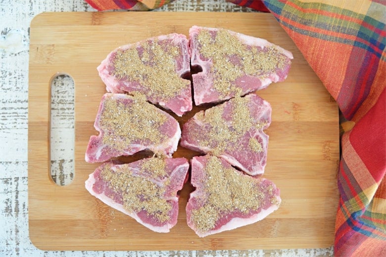 Seasoned lamb chops o a wood cutting board 