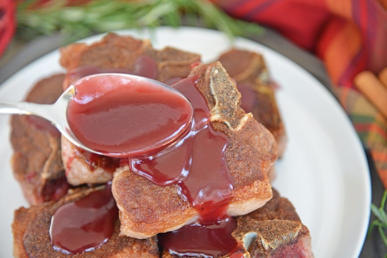 Pomegranate gravy spooning over lamb chops 