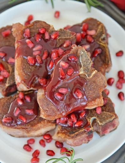 pomegranate lamb chops on a white platter