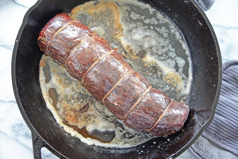 Reverse sear beef tenderloin in a cast iron pan with butter 