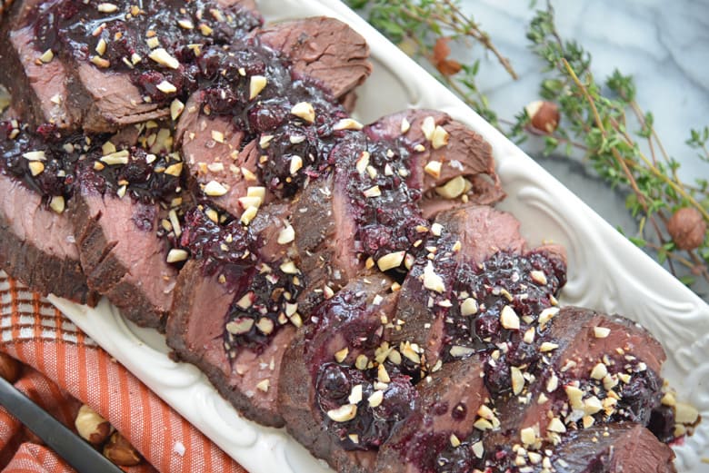 Sliced beef tenderloin on a serving platter