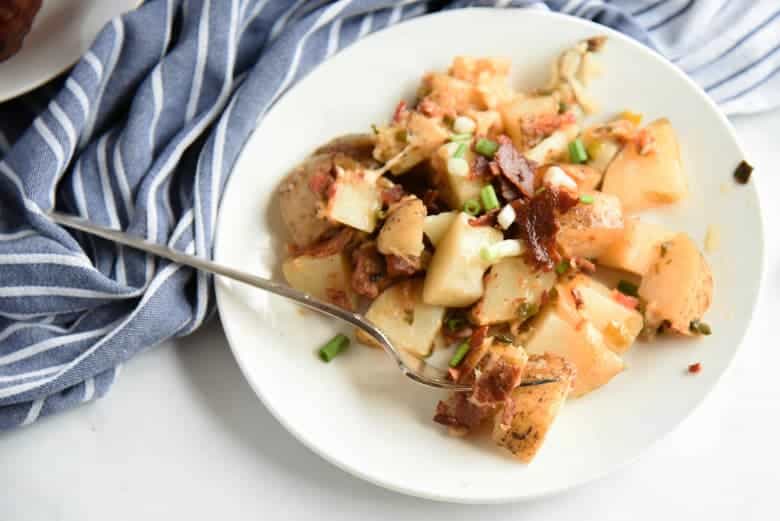 Slow cooker potatoes on a white serving dish 