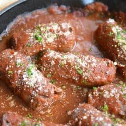 beef braciole in a cast iron pan