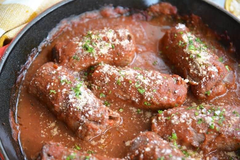 beef braciole in a cast iron pan