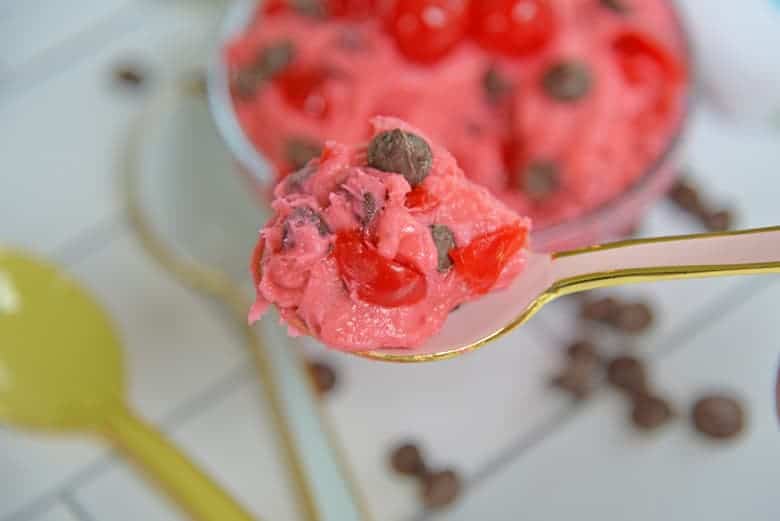 Spoon full of chocolate chip cookie dough with candied cherries 