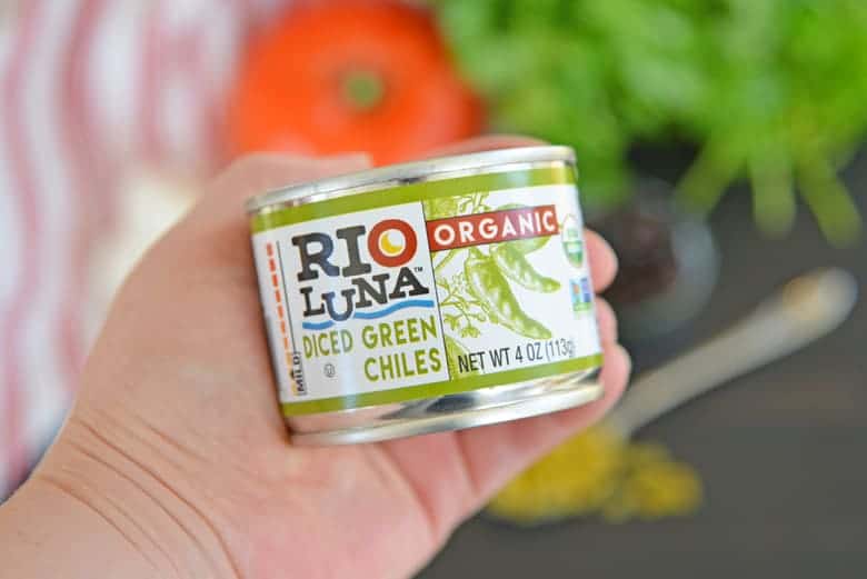 Hand holding organic green chiles 