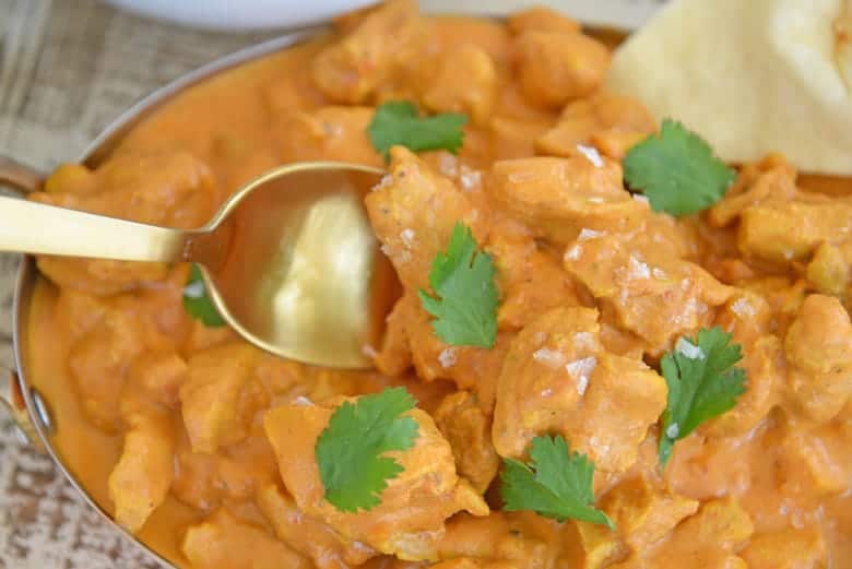 Spoon dipping into Indian Butter Chicken 