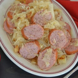 A plate of food on a table, with Kielbasa and Sauerkraut