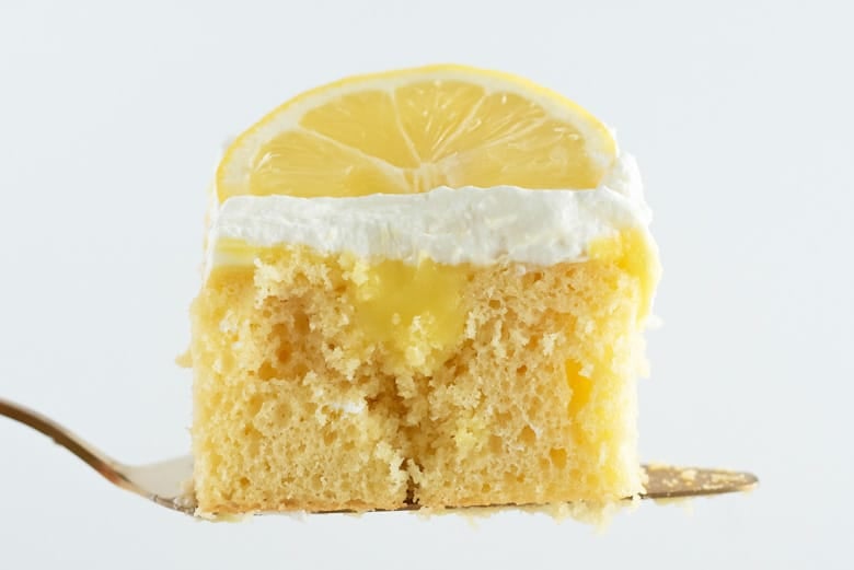 Slice of lemon poke cake on a spatula 