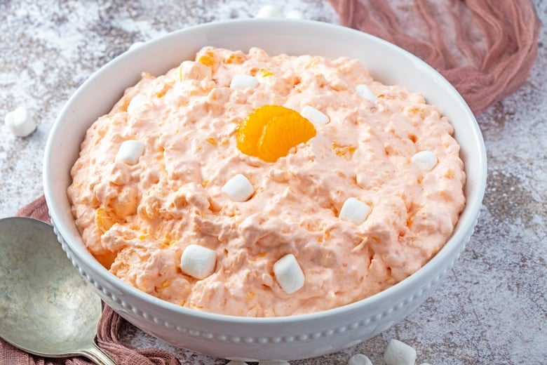 Angle view of orange fluff salad in a white serving bowl 
