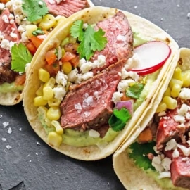 A close up of a plate of food, with Steak and Taco