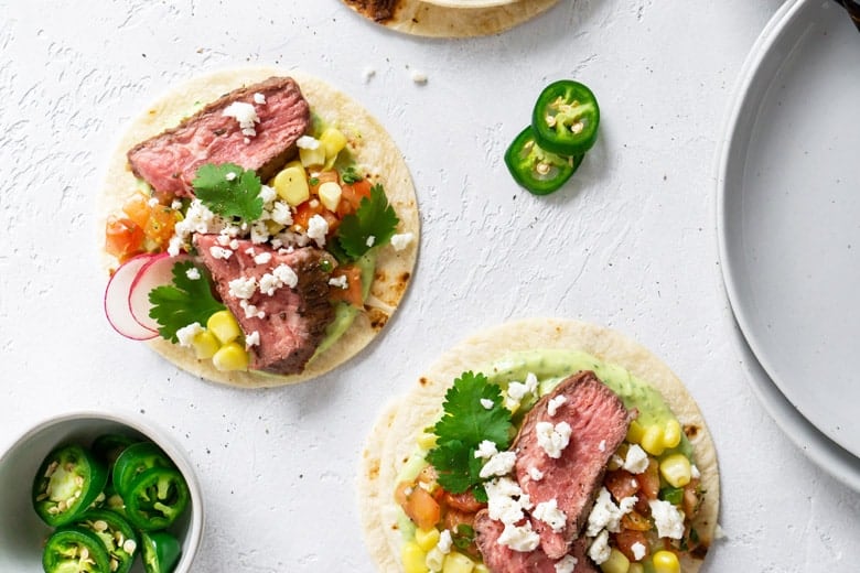 flank steak tacos on a white board