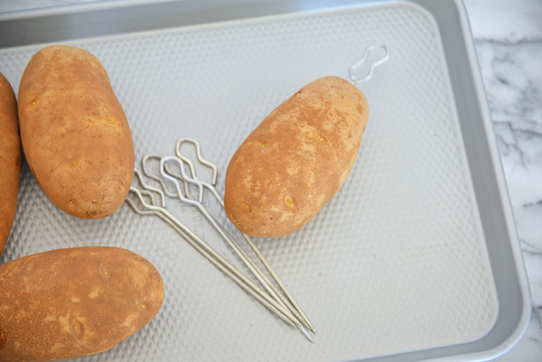 Potatoes on a baking sheet with potato nails 