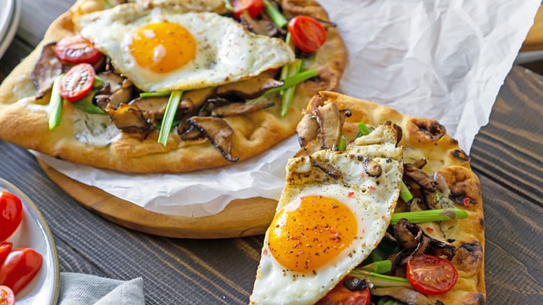 Breakfast pizza with vegetables and runny egg