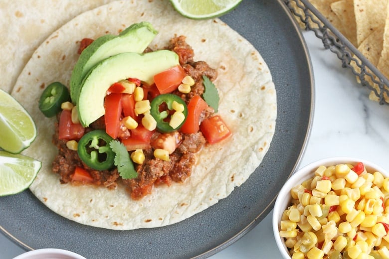 soft taco with ground taco meat, avocados, tomatoes and jalapenos 