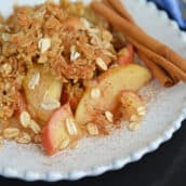 white plate of apple crisp with oatmeal crumble topping