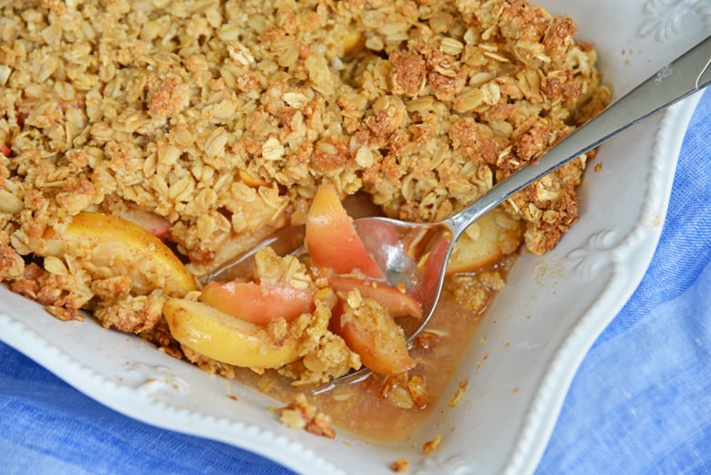 spooning out hot apple crisp 