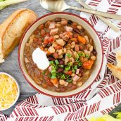 overhead of 15 bean soup in a bowl with bread and cheese