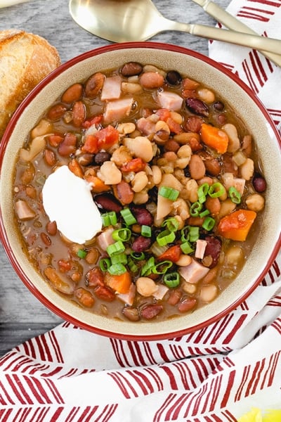 overhead of 15 bean soup in a bowl with bread and cheese