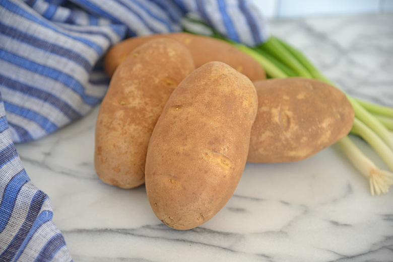 raw potatoes on a cutting board 