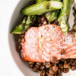 salmon on top of lentils on a plate