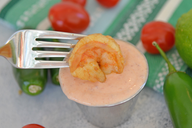 Shrimp dipping into sriracha sour cream sauce  