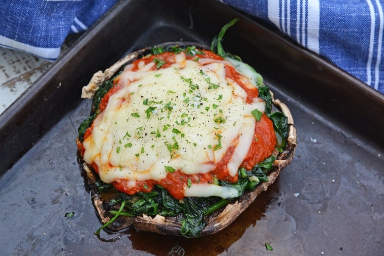 melted cheese on spinach stuffed mushrooms 