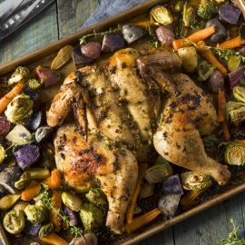 rimmed baking sheet with roast chicken and vegetables